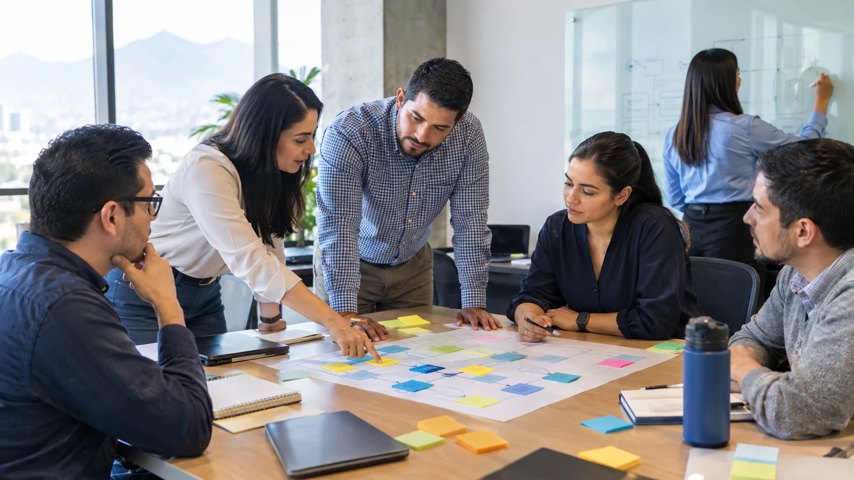 Equipo de trabajo en un taller, ordenando un mapa de proceso con notas
